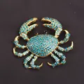 Close-up detail of a golden crab brooch encrusted with shimmering blue rhinestones - Lake Blue Rhinestone Gold Crab