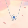 Detailopname van een zilveren ketting met maan en sterren hanger en blauwe kraal - Cluster Instelling