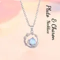 Detailweergave van een zilveren planeethanger ketting met een lichtblauwe maansteen - Planeet Stijl
