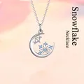 Elegante zilveren halve maan halsketting met een delicate blauwe kristallen sneeuwvlok hanger. - Sneeuwvlok / Eenvoudige Verpakking