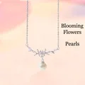 Detailopname van een zilveren bloemen-kristallen ketting met een witte parelhanger - Bloemen Kunstparel / Eenvoudige Verpakking