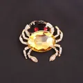 Detailed luxury gold-tone crab brooch featuring a large yellow gemstone and rhinestones - Yellow Gem Black Crab