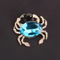 Elegant gold crab brooch with blue crystal and rhinestones on black background - Dark Blue Gem Gold Crab