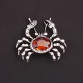 Intricate crab-shaped brooch featuring an amber-toned center stone and sparkling rhinestones - Amber Gem Silver Crab
