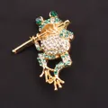 Prachtige vergulde kikkerspeld met groene en witte kristallen die fluit speelt - Kikker Speelt Fluit Broche (G6-3-1354)