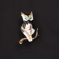 Vintage uil broche met zwart en wit emaille en groene edelsteen ogen op zwarte stof. - Zwart Witte Emaille Groene Ogen Uil (J8-3-1332)