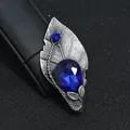 Detail van vintage bladbroche met grote blauwe edelsteen en antiek zilveren afwerking - Bladvorm met Blauwe Druppelsteen