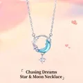 Gedetailleerd overzicht van zilveren maan en ster hanger ketting met blauw kristal. - Achtervolg de Sterrenmaan / Eenvoudige Verpakking