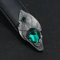 Detailopname van een vintage etnische bladspeld met groen kristal in een tin-afwerking - Bladvorm met Groene Druppelsteen
