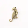 Detailed macro view of a vintage golden leopard brooch with green jeweled eyes. - Vintage Gold Looking-back Leopard (o1 - 6 - 5093)