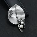 Detailopname van een vintage bladzilveren broche met witte parels en strass - Bladvorm met Parel en Strass