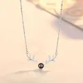 Macro view of antler pendant necklace with central projection stone and crystal accents - Antler Projection / Simple Packaging