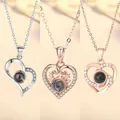 Hartvormige projectie halskettingen in zilver en roségoud met 100 talen Ik hou van jou - Hart aan Hart, Hartgewei en Liefde Vortex Set