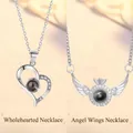 Projection necklace featuring heart and angel wing designs in a silver finish. - Heart and Wings Projection