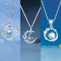 Detailansicht von drei eleganten Silberhalsketten mit Feder-, Mond- und Planetenanhängern. - Feder Mond Schmetterling und Pluto Stil / 3er-Set