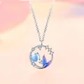 Mermaid tail necklace with a blue bead and star crystals on a soft pink background - Mermaid Bond