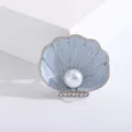 Elegante lichtblauwe emaille schelpbroche met een centrale parel en kleine strass - Lichtblauwe Emaille Kunstparel Wulk (b4-2-6229)