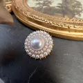 Vintage baroque style brooch featuring a large central pearl in a gold-toned setting - Round Layered Pearl Style