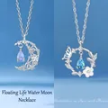 Elegante zilveren ketting met wassende maan en vlinder en blauwe kristallen hangers - Floating water moon + butterfly love flower / Geschenkdoos
