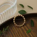 Vintage matte gold round circle brooch with textured beads on a wooden tray jewelry - Beaded Texture Style