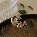 Elegant vintage matte gold metal brooch featuring a fairy sitting on a crescent moon - Moon Fairy Style