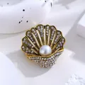 Vintage gouden schelp broche versierd met een centrale parel en fonkelende strass - Retro Parel Wulk Stijl (b5-6-6378) / Goud