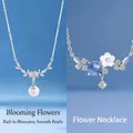 Elegant floral necklace set with pearl and crystal charms on blue background. - Floral Cluster & Endless Bloom (Set of 2)