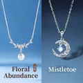 Elegant silver necklaces featuring floral pearl and crescent moon pendants on blue - Floral Cluster & Mistletoe (Set of 2)