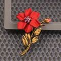 Detailed view of a vintage red flower brooch with antique gold stem and leaves - Red