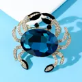Close-up of a luxury crab brooch with a faceted blue crystal and sparkling rhinestones - Blue