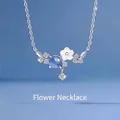 Elegant silver flower branch necklace featuring a blue bead and white shell petal charm - Eternal Floral