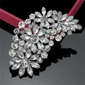 Detailed macro shot of an elegant feather-shaped brooch with sparkling clear glass crystals - Silver White