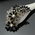 Detailed macro view of black and clear crystal flower brooch with gold-toned metal base - Gold Black