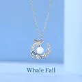 Elegant silver whale pendant necklace with a white pearl and shimmering stones. - Whale Fall Style