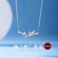 Elegant silver bamboo pendant necklace featuring a clear zircon stone on blue background - Bamboo of Contentment