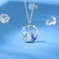 Mermaid tail pendant necklace with blue bead and crystals on light blue background - Mermaid Bond