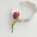 Detailed view of an elegant burgundy tulip brooch with sparkling rhinestones and enamel - Red