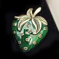 Macro detail view of a vintage green enamel strawberry brooch featuring gold leaf accents - Green