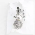 Close-up of a silver-toned snowman brooch with sparkling rhinestones and a white pearl - Snowman Style