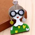 Macro di una spilla in acrilico fatta a mano a forma di ragazza con orecchini a cuore - Verde