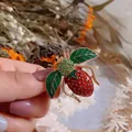Detailed macro view of a vintage-style bee brooch with strawberry abdomen and leaf wings - Bee Strawberry Shape (Bee) / Red and Green Bee