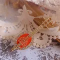 Close-up of a vintage Pipa musical instrument brooch with orange enamel and rhinestones - Orange and Gold Pipa
