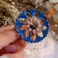 Gedetailleerd overzicht van een vintage blauwe geëmailleerde bloembroche met parelinleg - Opengewerkt Bloembladontwerp (Golf) / Holle Bloem