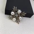 Detailed macro view of a vintage cross brooch with elegant pearls and sparkling rhinestones - Geometric Cross Style (X0445)