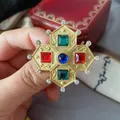 Detailansicht einer Vintage-Barockbrosche mit bunten Edelsteinen in Mattgold - Mehrfarbiger Edelstein Rhombus-Stil