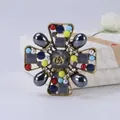 Gedetailleerd overzicht van een vintage kruisbroche met kleurrijke kralen op een doos - Stijl 9 (Kleurrijk Opengewerkt Rozenkruis)