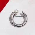 Minimalist silver C-shaped metal brooch with a single white pearl for suit accessory. - Silver