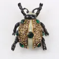 Élégante broche scarabée avec strass verts et finition dorée pour accessoiriser vos vêtements - Ambre Et Vert