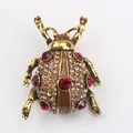 Magnifique broche coccinelle vintage dorée avec strass rouges et couleur champagne - Or Antique/Rouge
