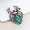 Elegante strass spin-broche met smaragdgroene kristallen en zilveren legering. - Groene Spin (m1-2-3219)